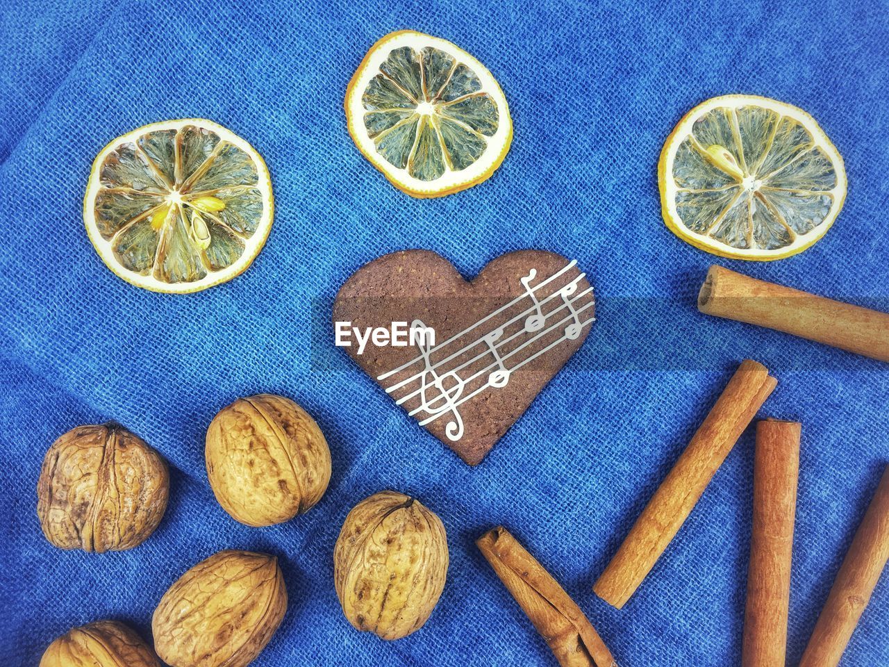 High angle view of gingerbread cookies with lemon and walnuts by cinnamon on table