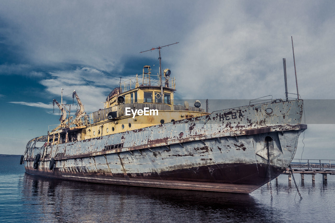 Abandoned ship amidst sea against sky