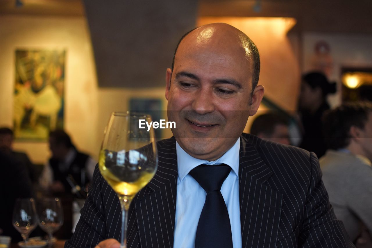 Close-up of businessman having wine at restaurant