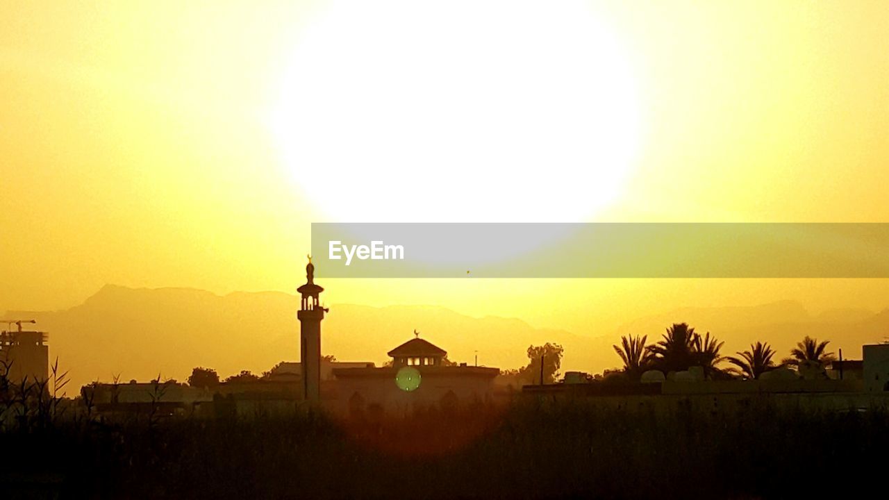 SILHOUETTE BUILT STRUCTURES AGAINST SKY DURING SUNSET