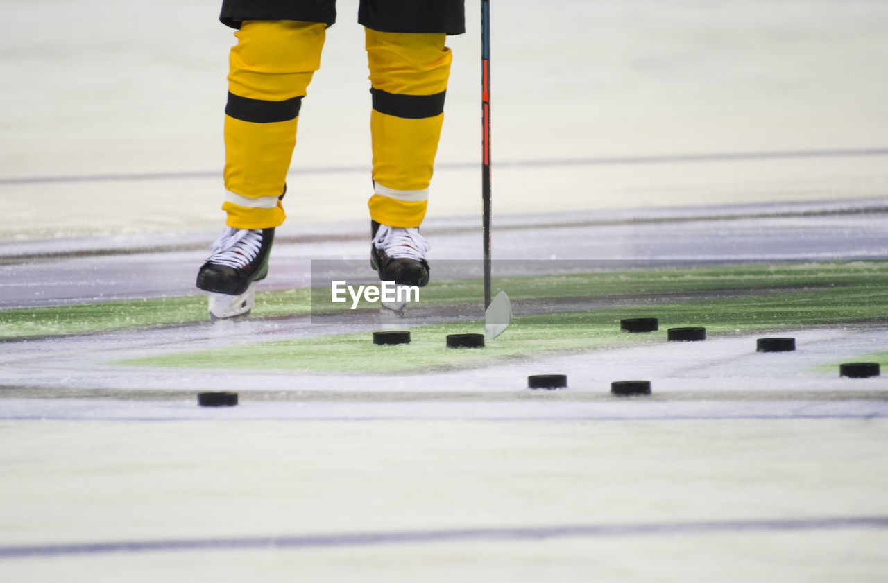 Low section of person playing ice hokey in rink