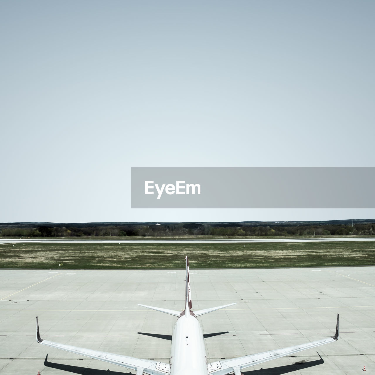 Airplane on runway against clear sky