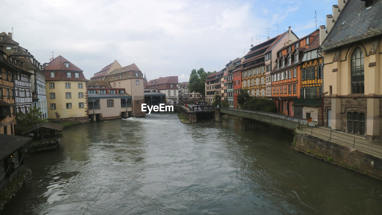 River amidst buildings in city against sky