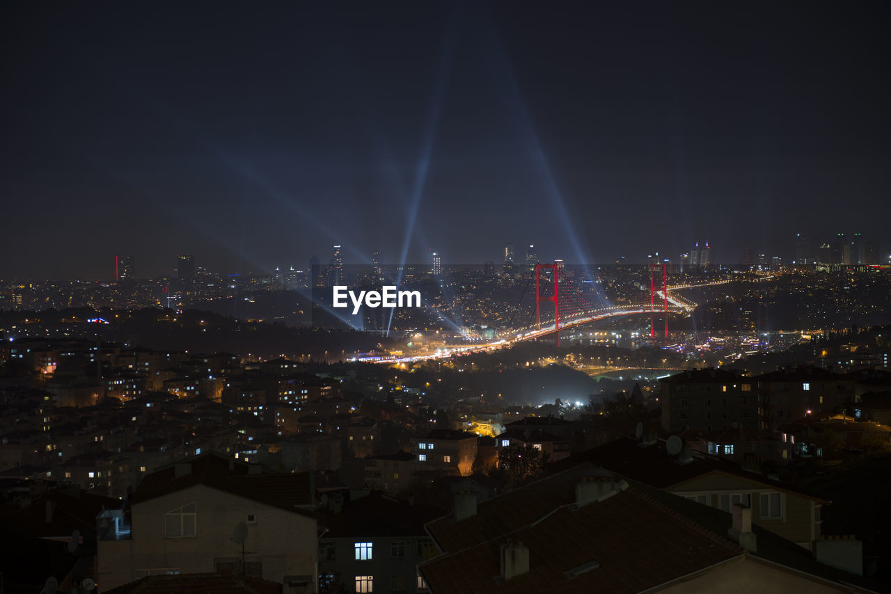 Illuminated cityscape against sky at night