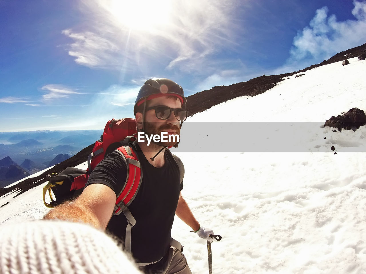 Man wearing sunglasses skiing on snow against sky during winter