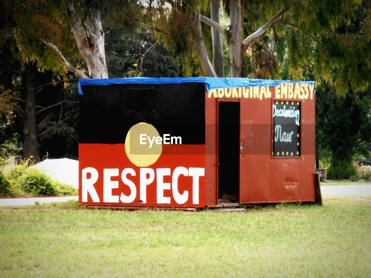 Text on metallic cabin on grass in park