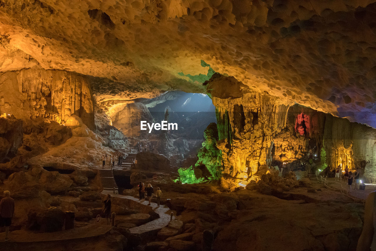 People walking on pathway in cave