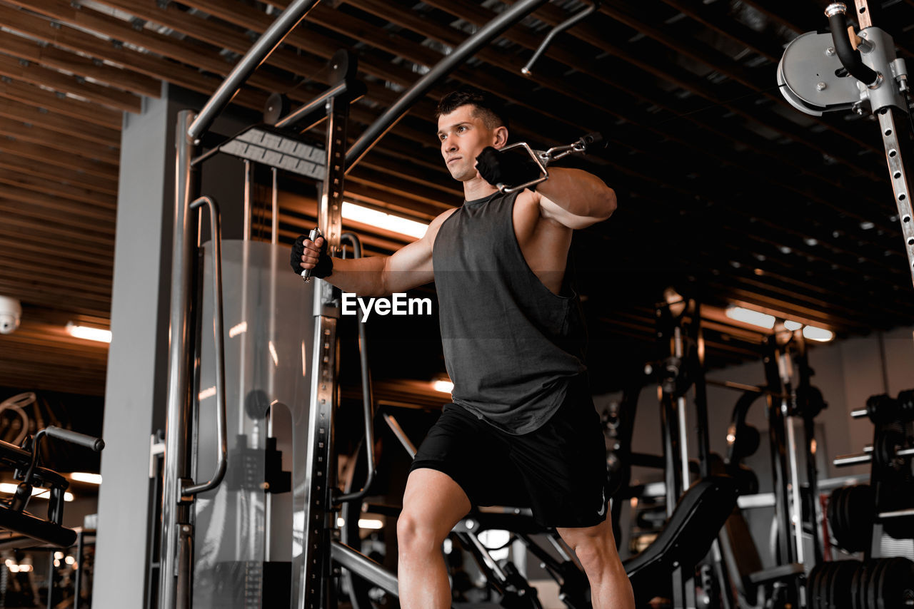 shirtless muscular man exercising in gym