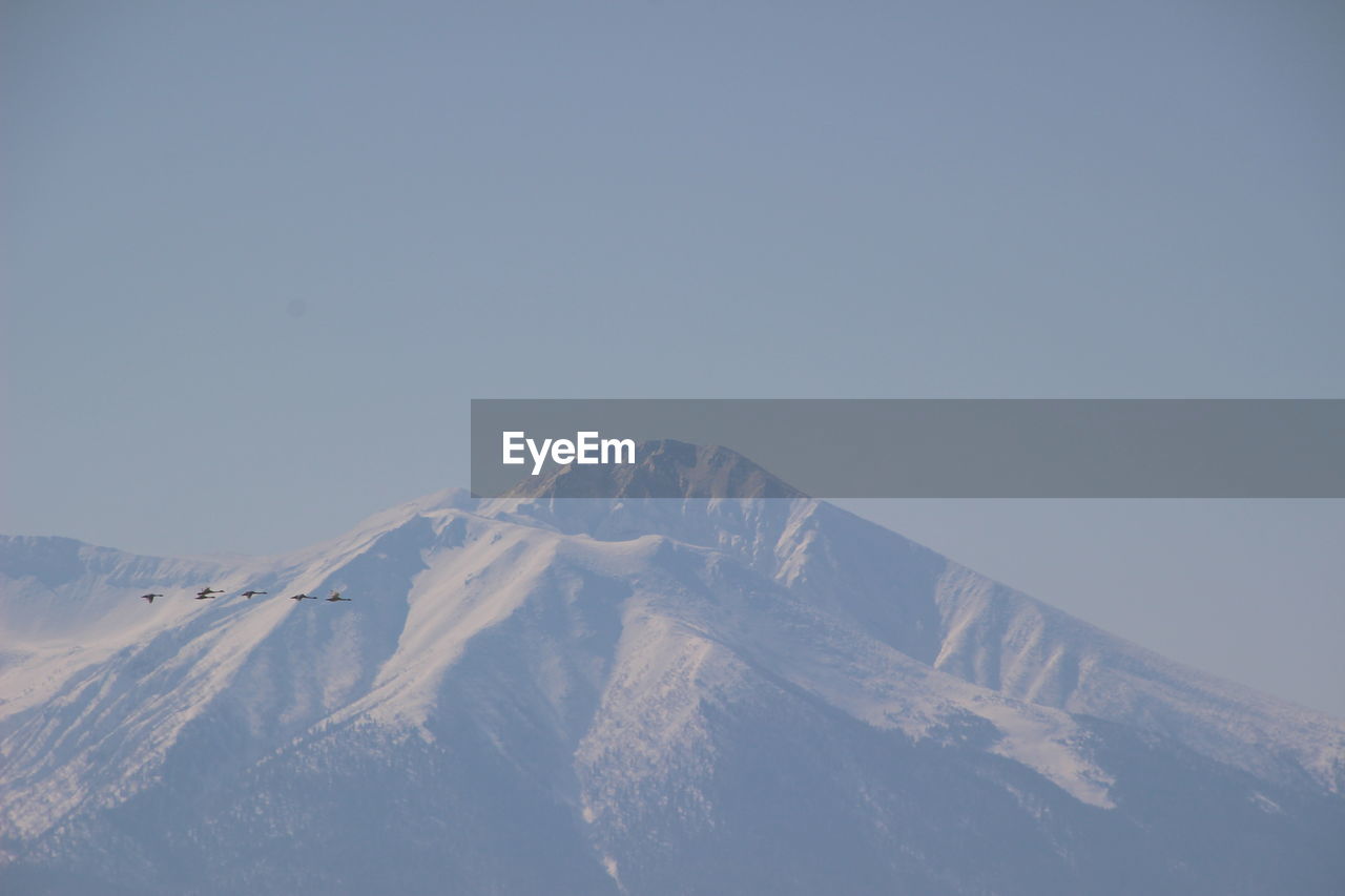 Aerial view of snow covered mountain against sky