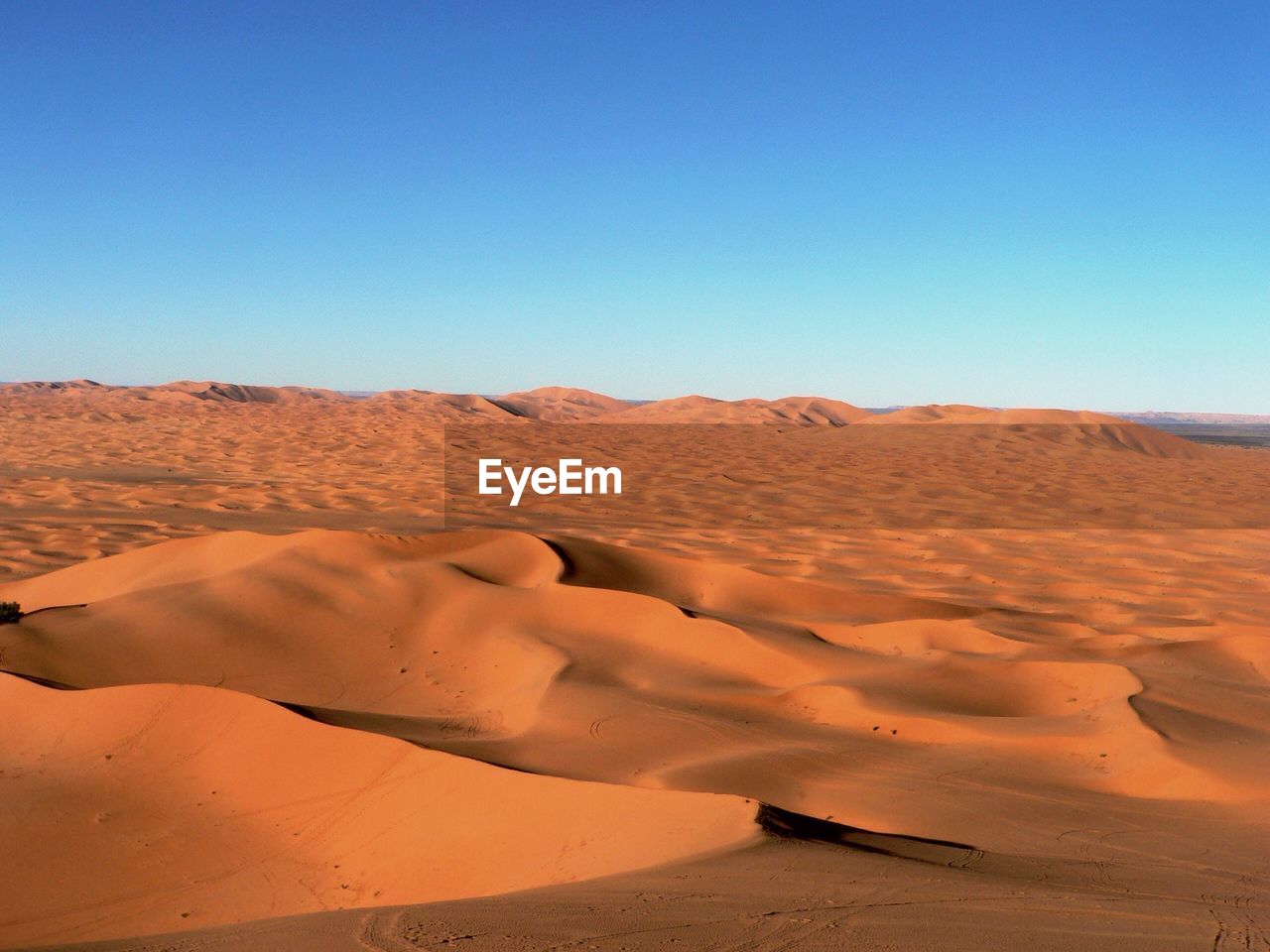 Sand dune against blue sky