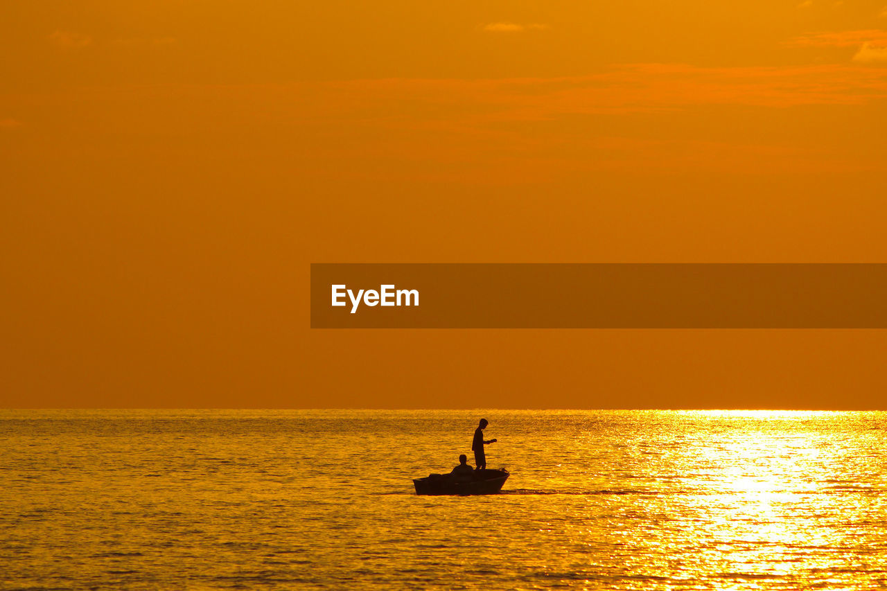 SILHOUETTE BOAT SAILING IN SEA AGAINST SKY DURING SUNSET