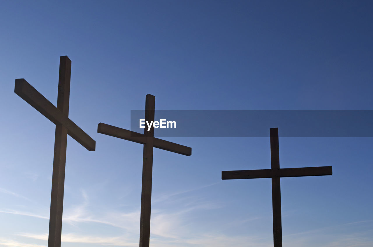 LOW ANGLE VIEW OF CROSS ON COLUMN AGAINST SKY