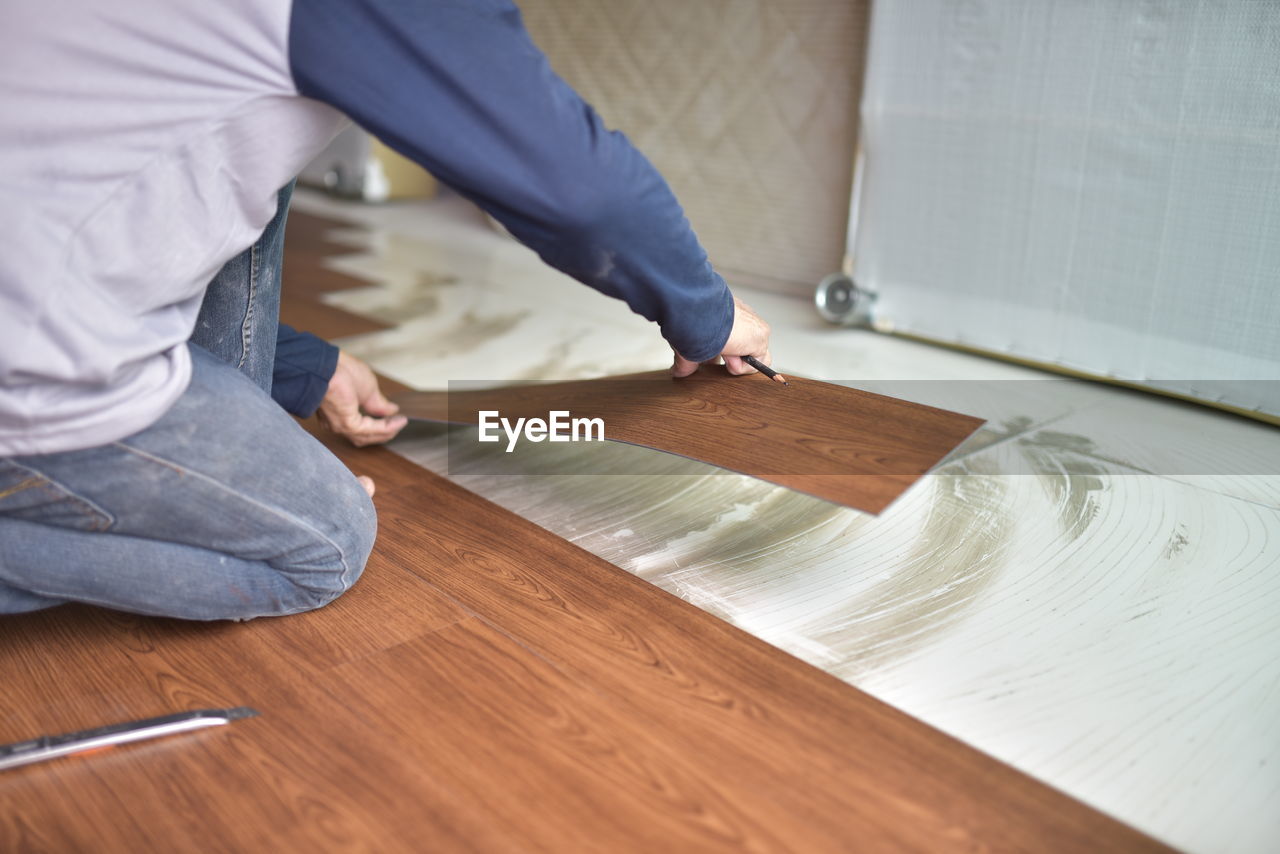 REAR VIEW OF MAN WORKING ON TABLE