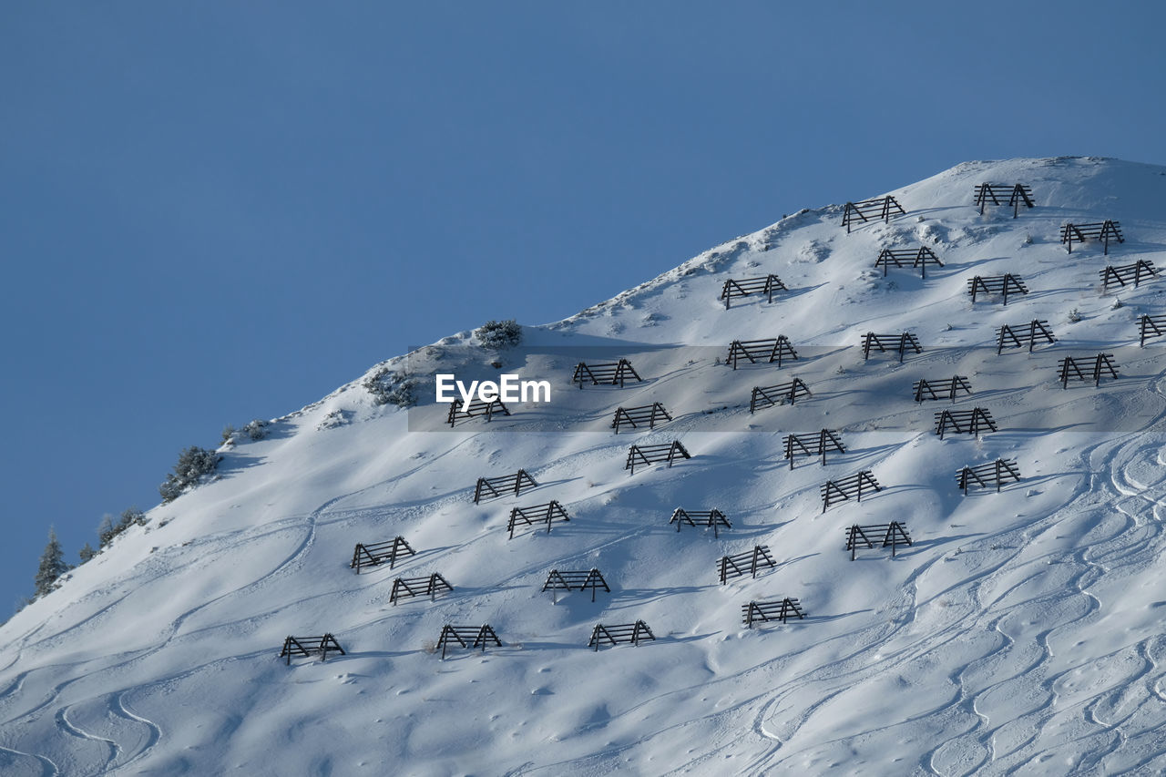 Avalanche controls and off piste 's first tracks in  deep powder snow in a severe mountain.