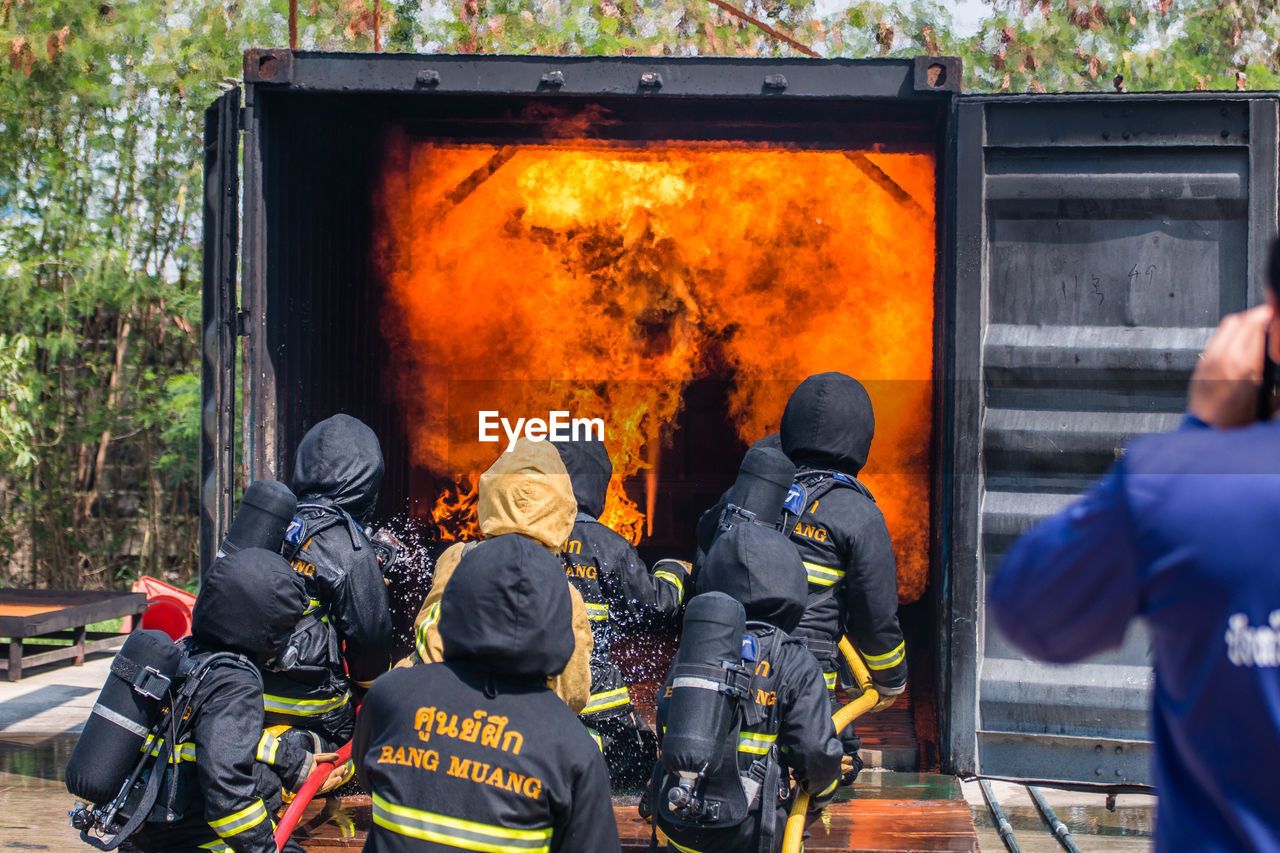 Rear view of firefighters extinguishing fire