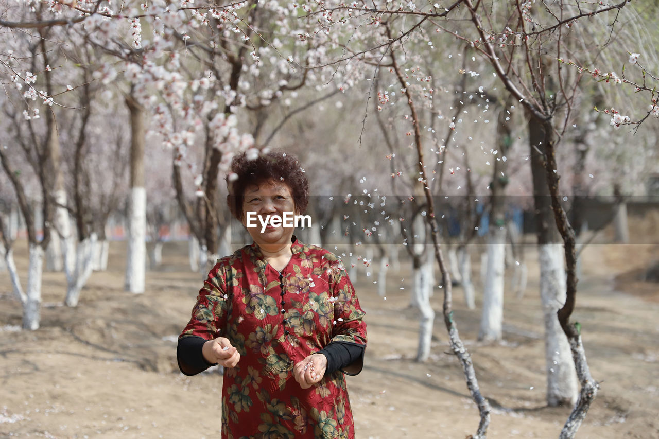 Senior woman standing at park during springtime