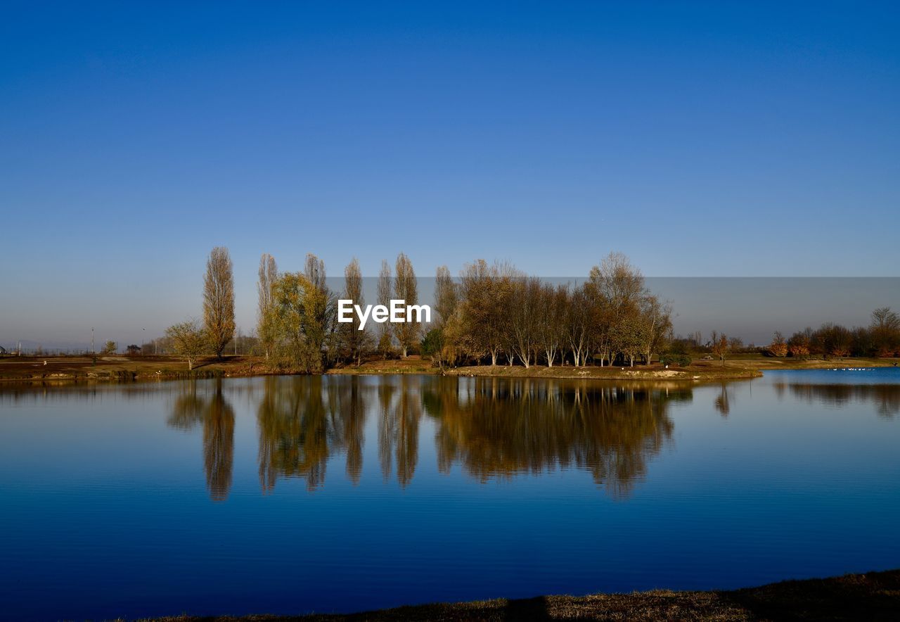 Scenic view of lake against clear blue sky