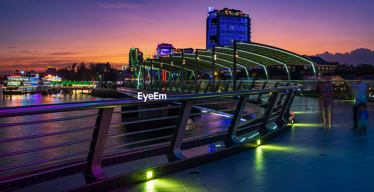 ILLUMINATED MODERN BUILDINGS AT WATERFRONT