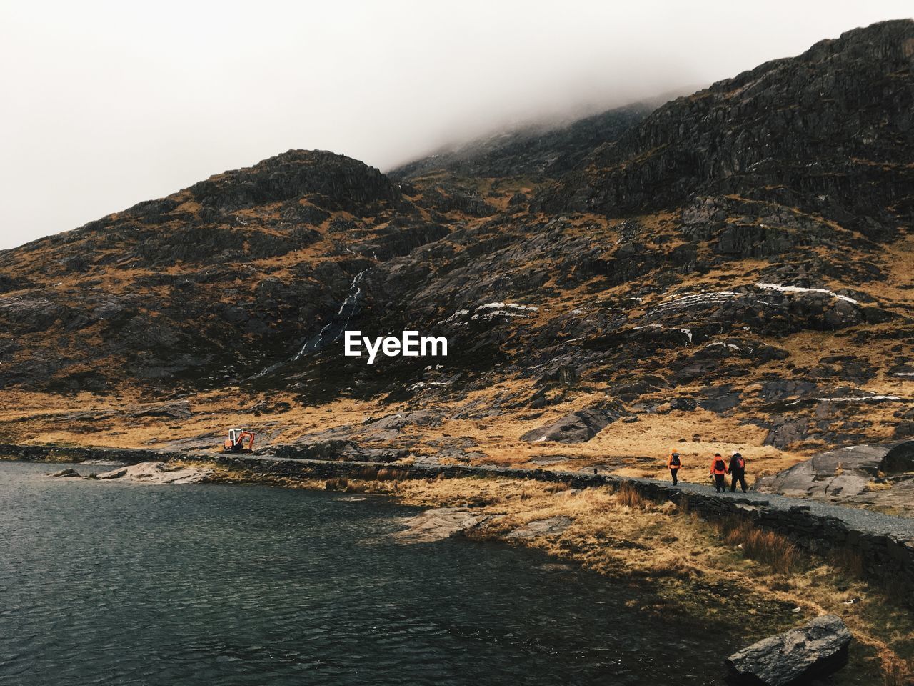 PEOPLE WALKING ON MOUNTAIN AGAINST SKY