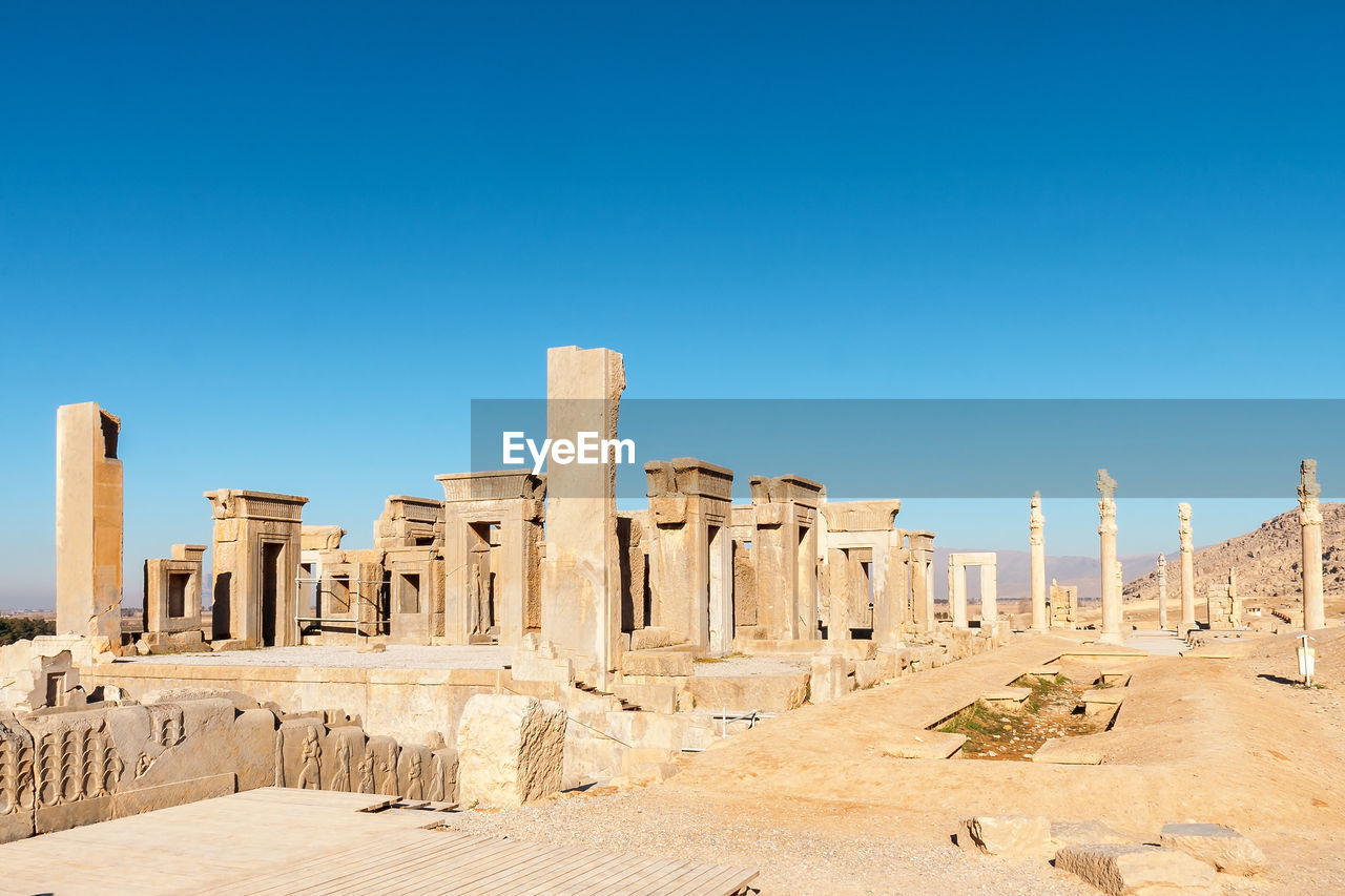 Ruins of ancient temple against clear blue sky