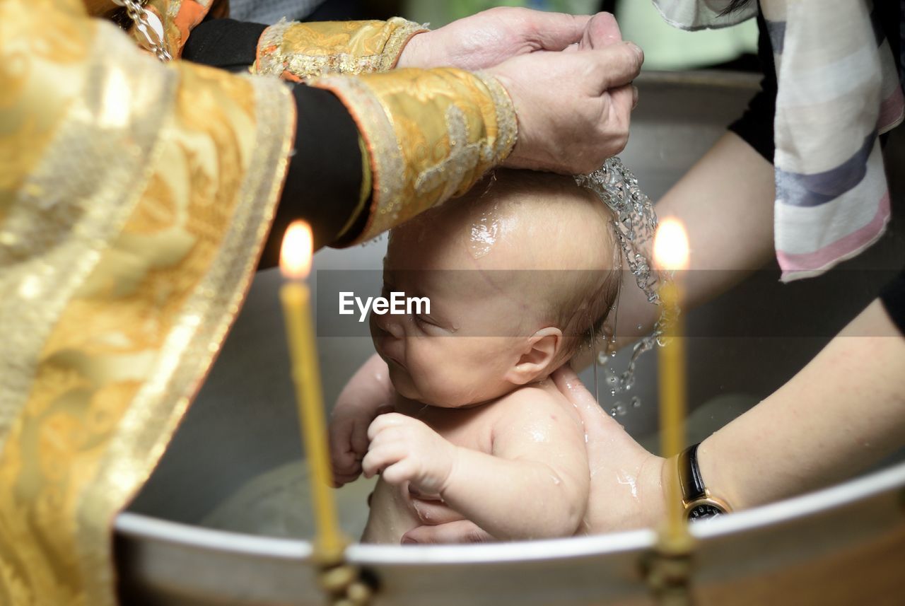 Cropped image of parents bathing baby boy