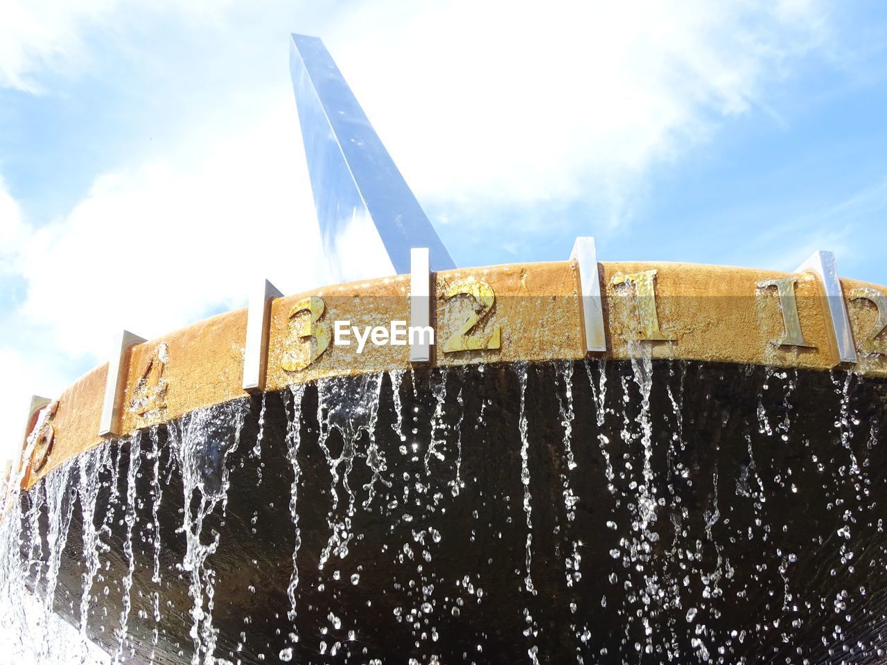 LOW ANGLE VIEW OF FOUNTAIN IN FRONT OF BUILT STRUCTURE AGAINST SKY