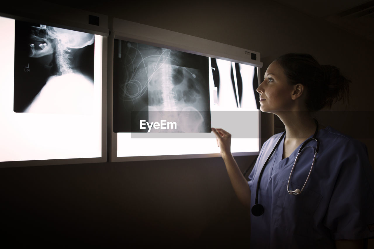 Woman looking at x-ray on diagnostic medical tool