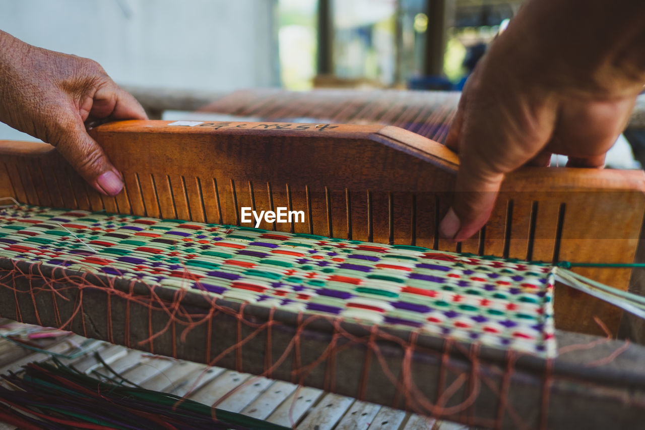 Cropped hands weaving loom