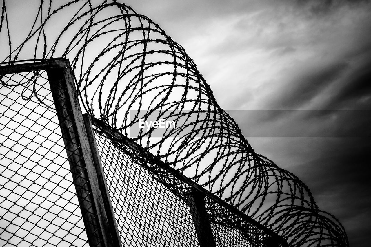 LOW ANGLE VIEW OF METAL FENCE AGAINST SKY