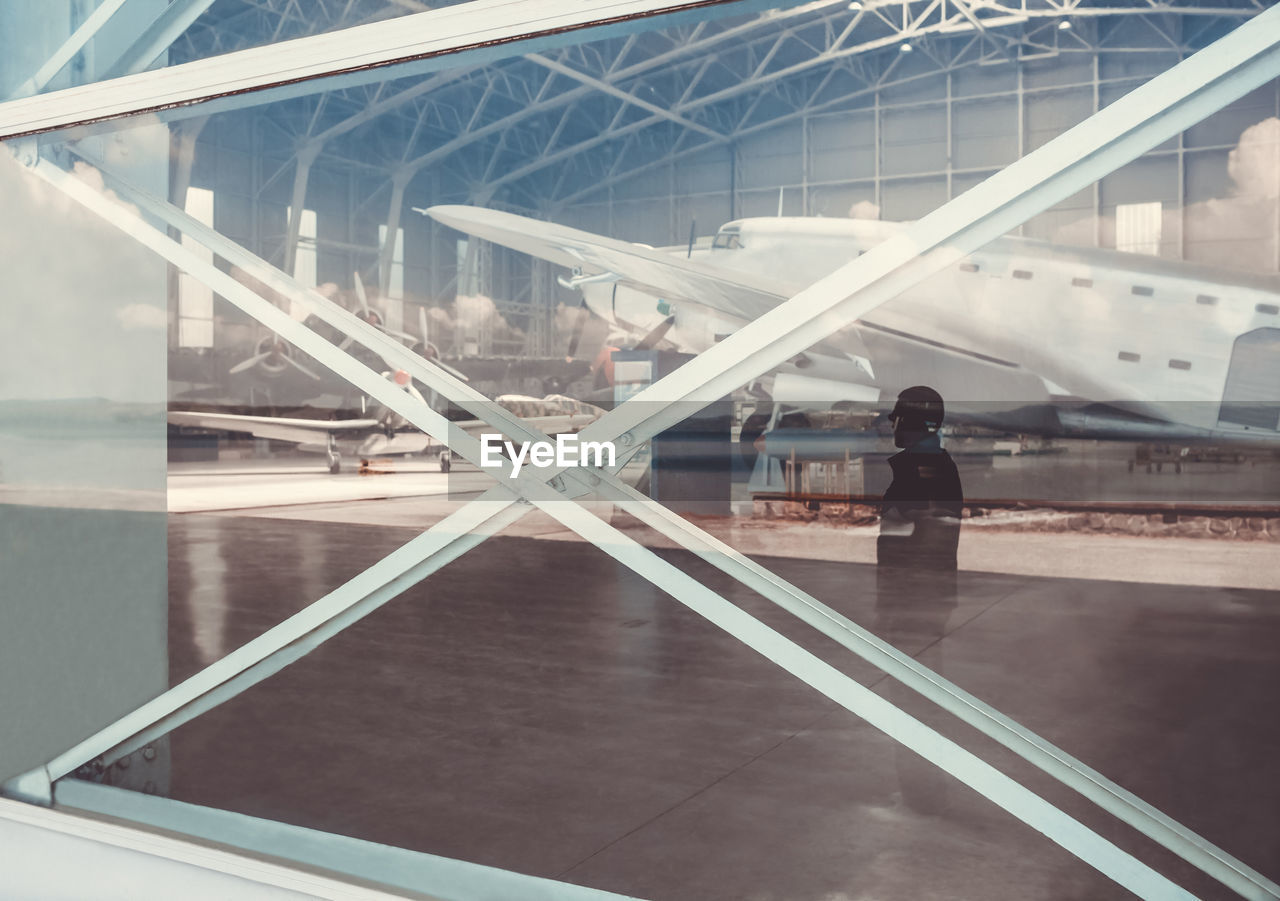 Reflection of man on window at airport