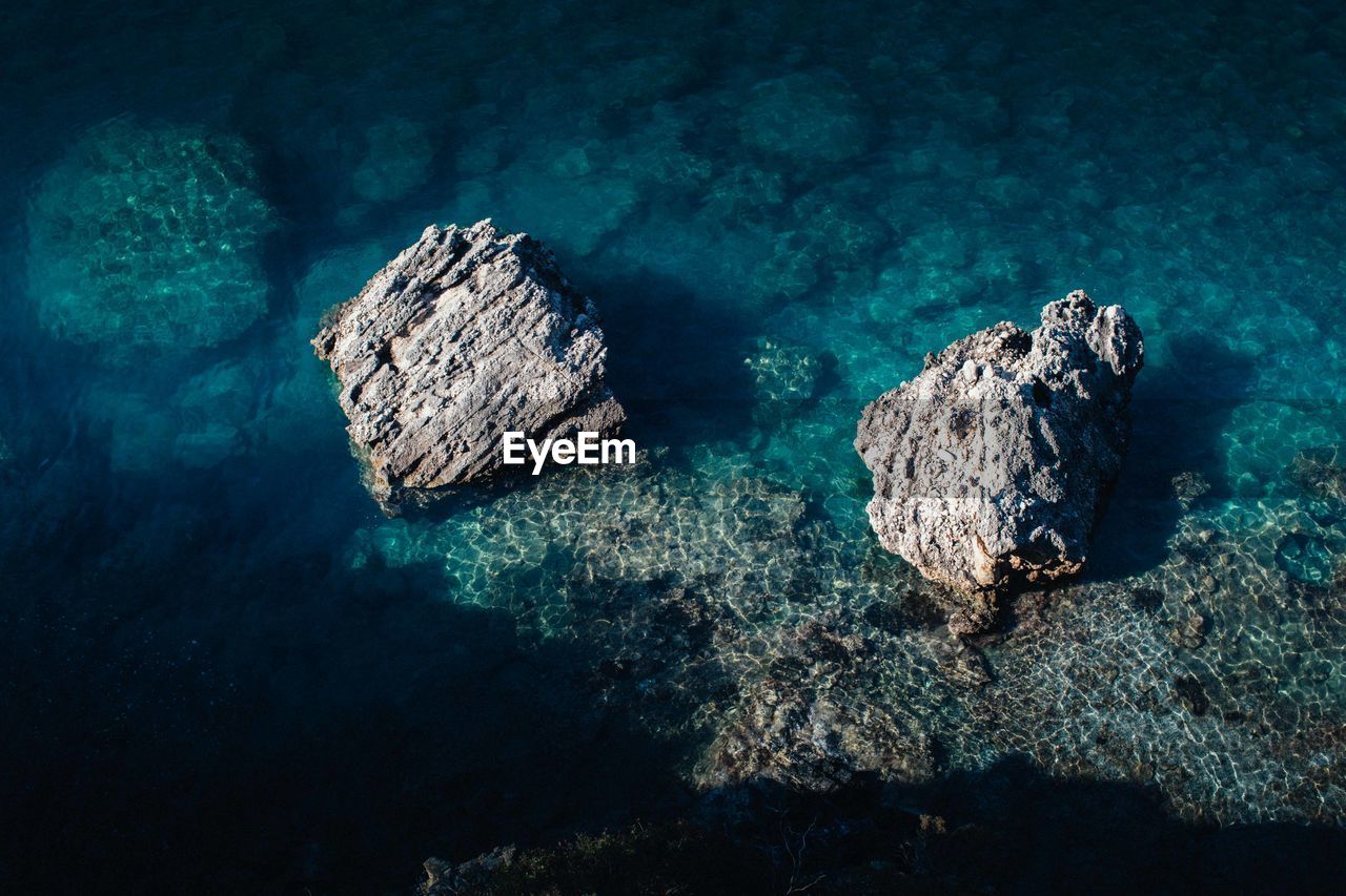 ROCKS IN SEA AGAINST ROCK FORMATION