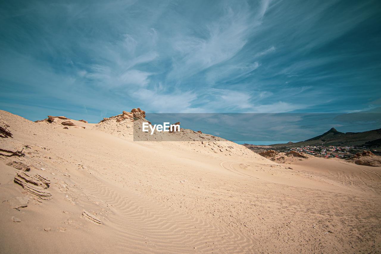 Sand dunes in desert against sky