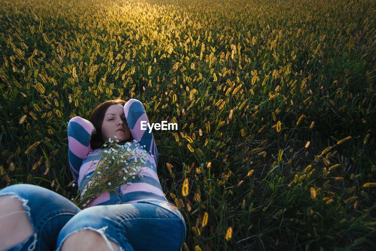 High angle view of woman lying on grassy field