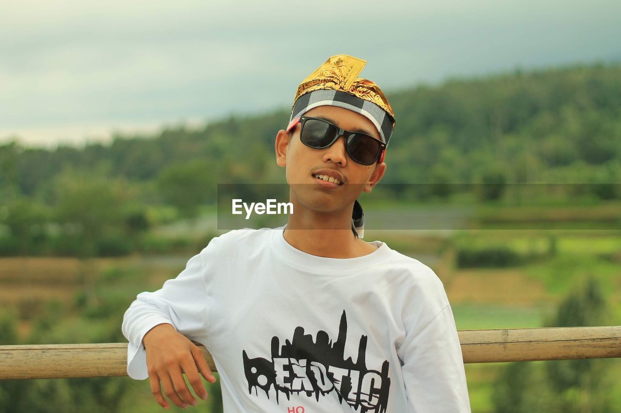 Portrait of young man wearing sunglasses standing outdoors