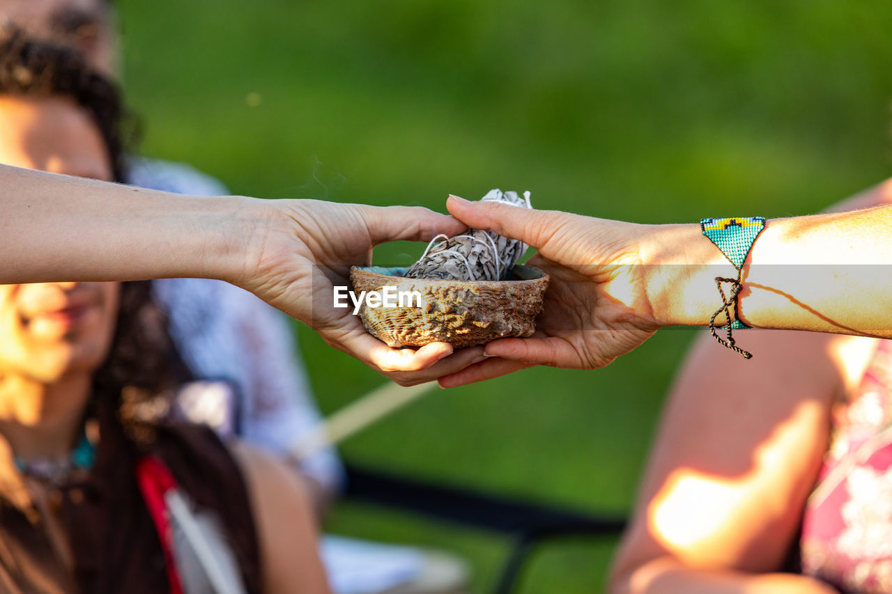 Cropped hands holding bowl and papers