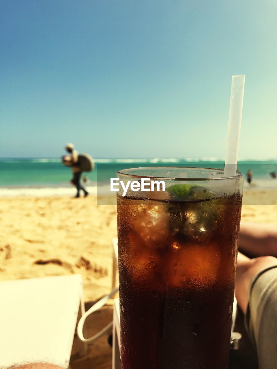 CLOSE-UP OF BEER IN GLASS ON BEACH