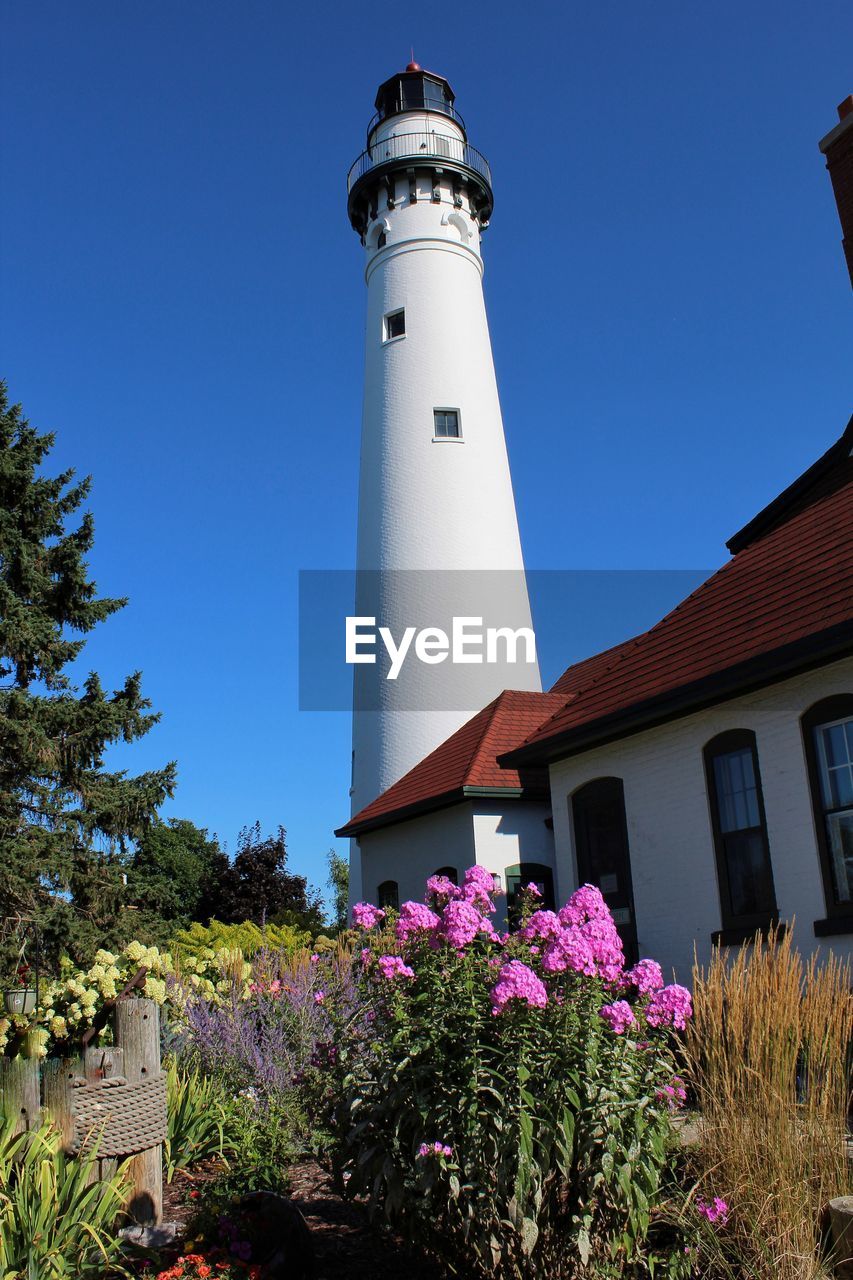 LOW ANGLE VIEW OF LIGHTHOUSE AGAINST BUILDINGS AND SKY