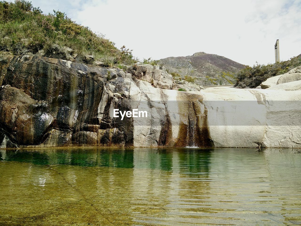 SCENIC VIEW OF ROCK FORMATIONS BY WATER