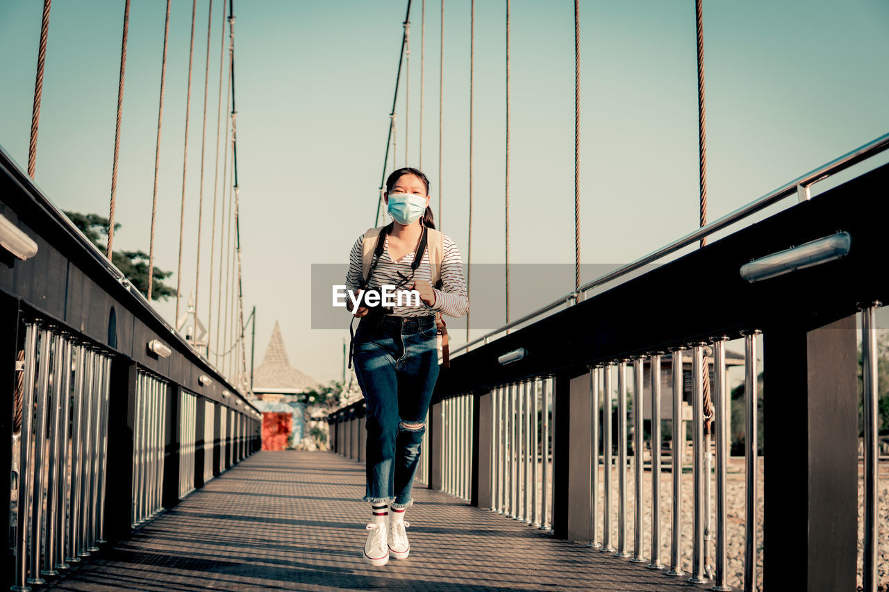 MAN STANDING ON BRIDGE