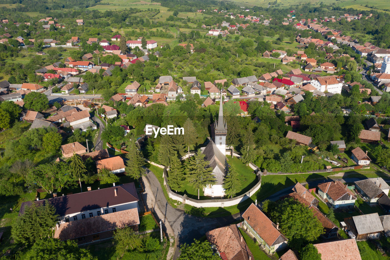 Aerial drone point of view of a whitewashed protestant church in manastireni, transylvania, romania