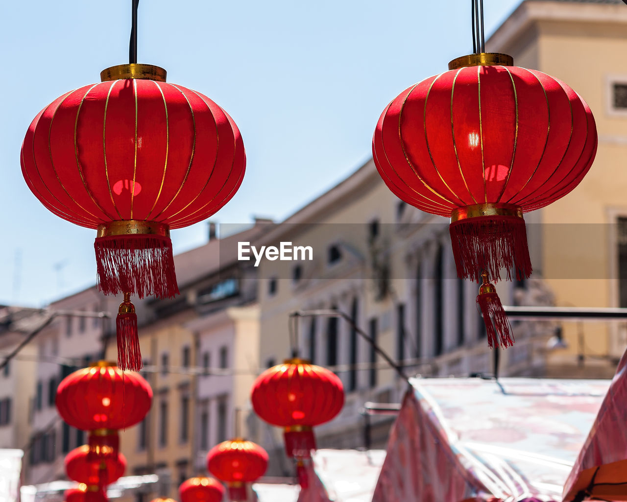 RED LANTERNS HANGING ON BUILDING AGAINST SKY