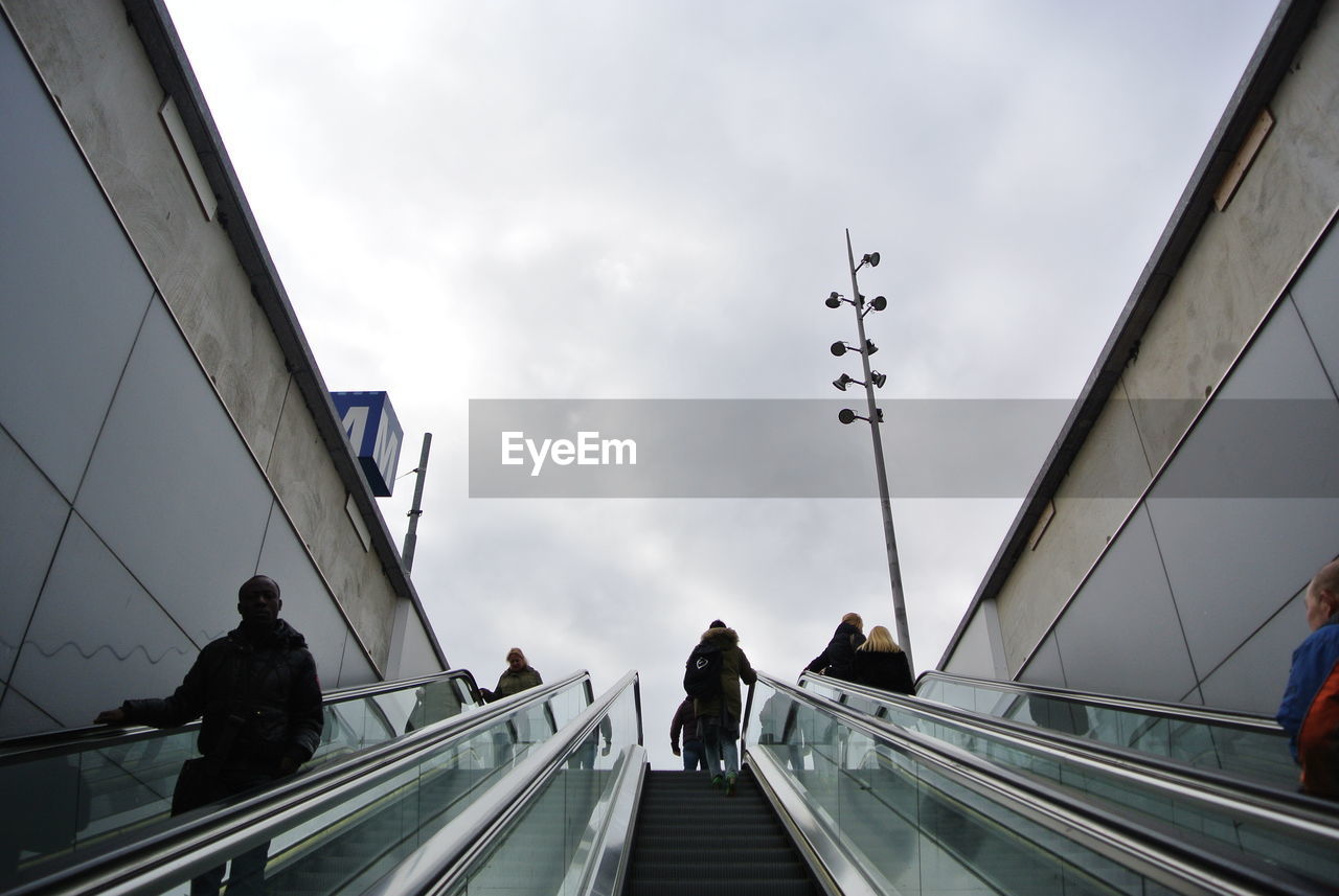 People on escalator against sky