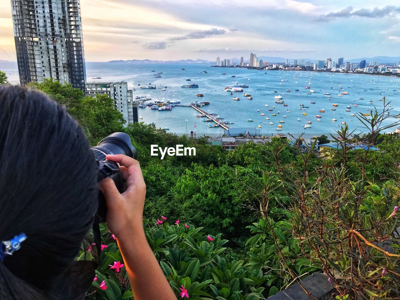 Rear view of woman photographing sea against sky