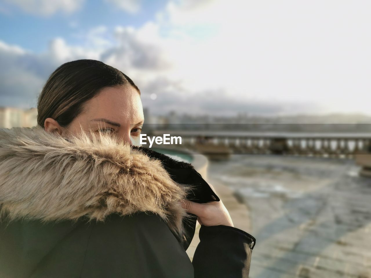 one person, fur, adult, warm clothing, coat, clothing, sky, winter, fur clothing, women, young adult, portrait, nature, architecture, water, fur coat, brown hair, focus on foreground, day, looking, city, jacket, photo shoot, cold temperature, standing, fashion, outdoors, leisure activity, hairstyle, lifestyles, headshot, copy space, waist up, female, cloud, travel destinations, hood, long hair