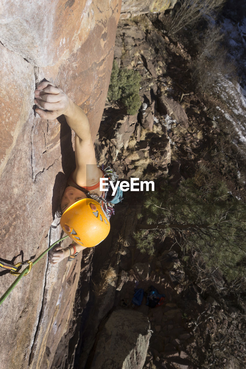 High angle view of confident female hiker climbing mountain