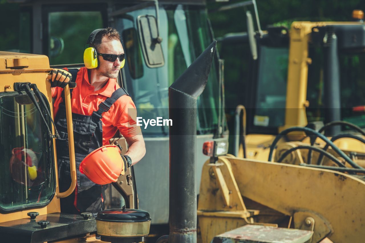 Worker standing by earth mover