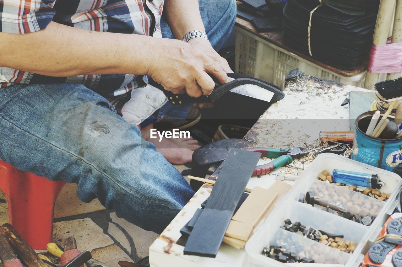 Midsection of carpenter working at workshop