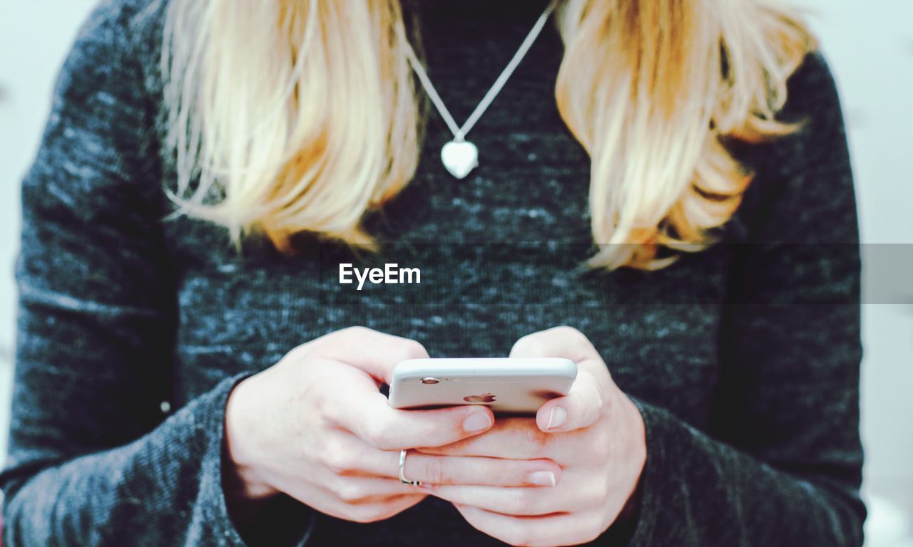 CLOSE-UP OF WOMAN HOLDING MOBILE PHONE