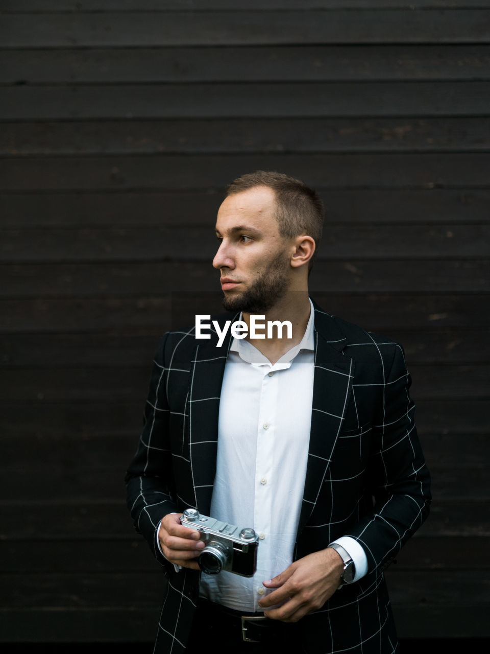 MAN LOOKING AWAY WHILE STANDING AGAINST WALL