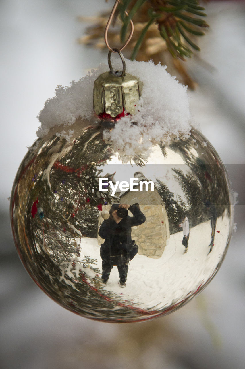 Reflection of woman with camera on bauble